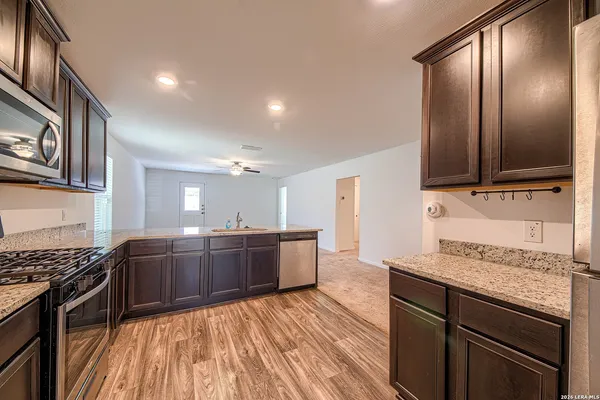 a kitchen with stainless steel appliances granite countertop a stove and cabinets