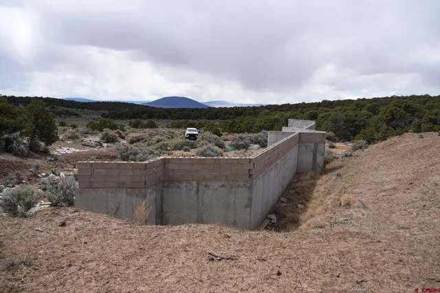 a view of a dry yard with wooden fence