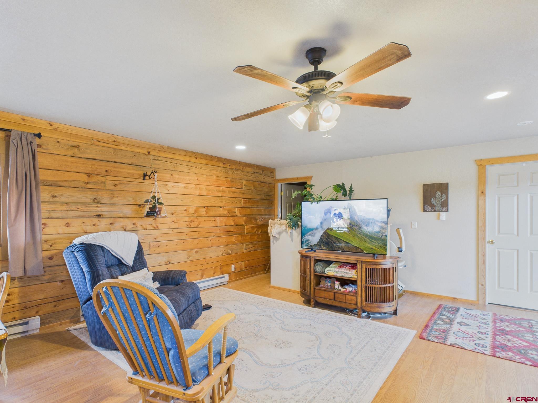 37569 Fruitland Mesa Road Crawford, CO 81415 - Photo 25 of 34 a bedroom with a bed and a chandelier