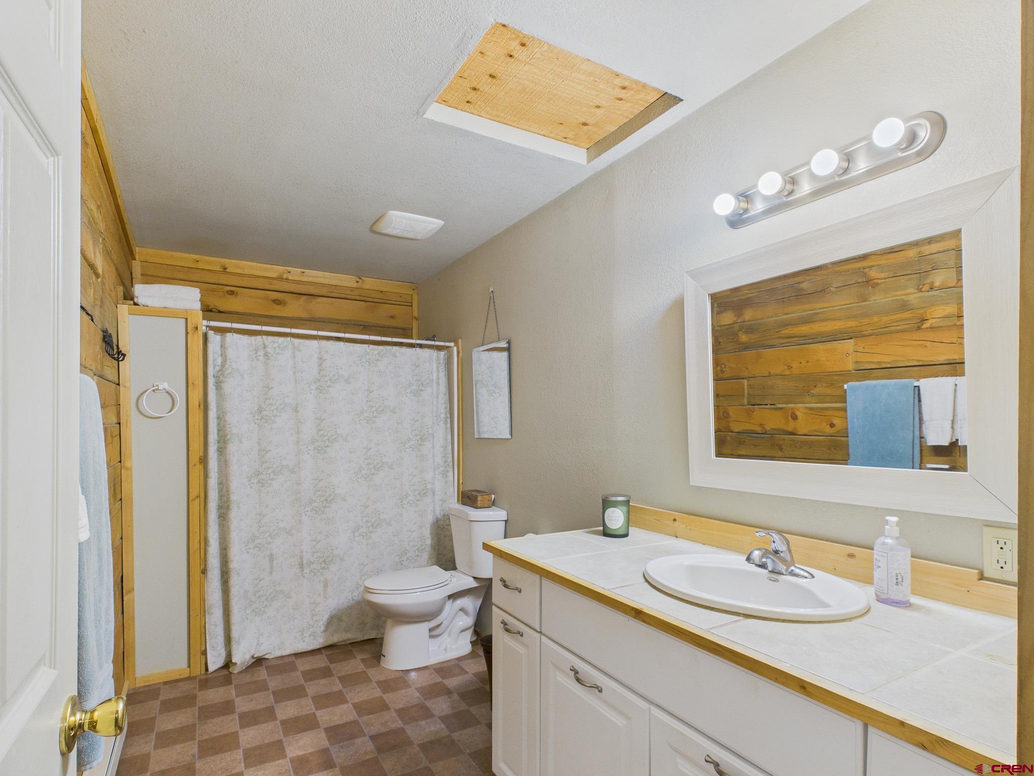 37569 Fruitland Mesa Road Crawford, CO 81415 - Photo 27 of 34 a bathroom with a granite countertop sink toilet and shower