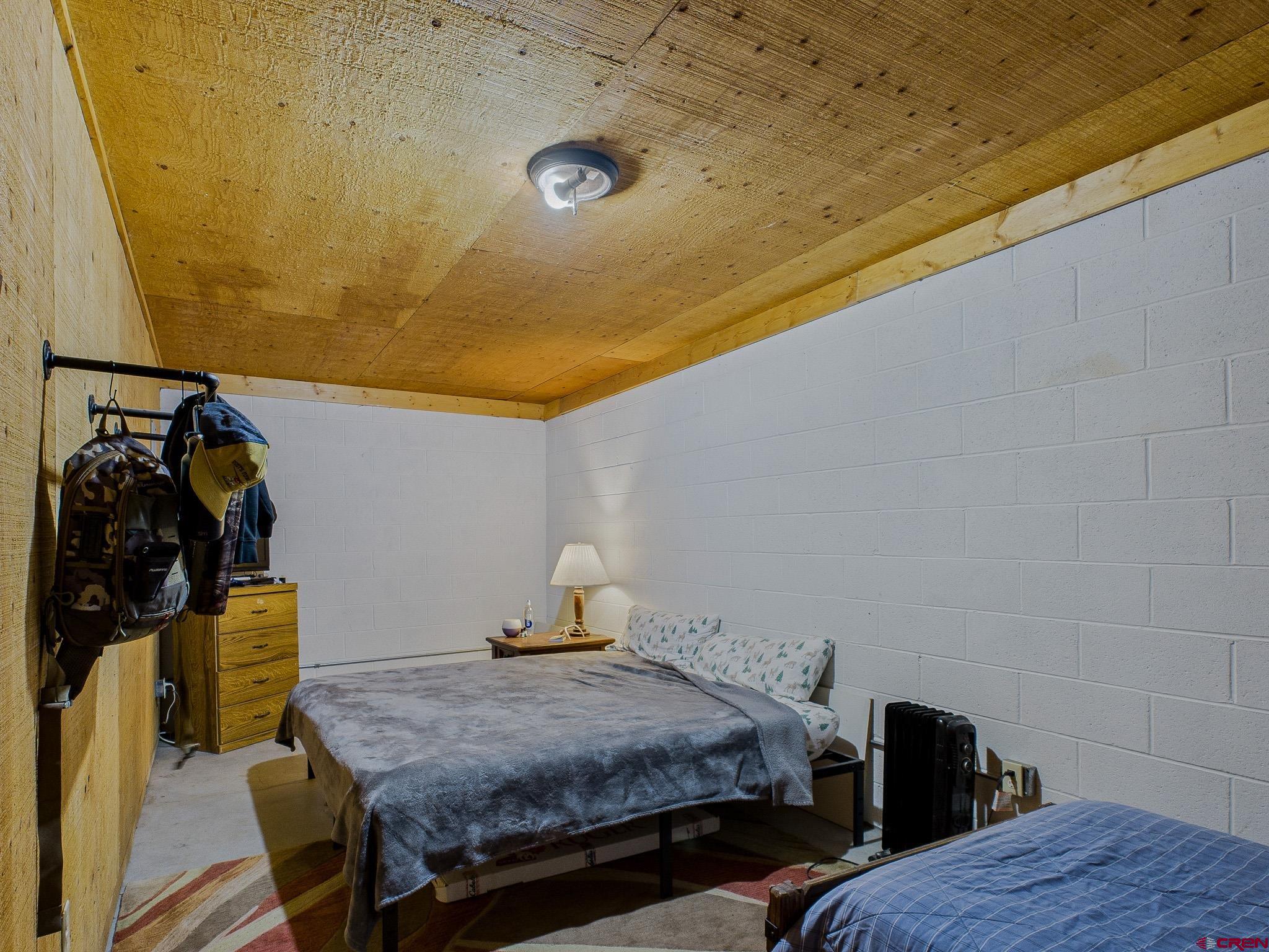 37569 Fruitland Mesa Road Crawford, CO 81415 - Photo 30 of 34 a bedroom with a bed and wooden floor