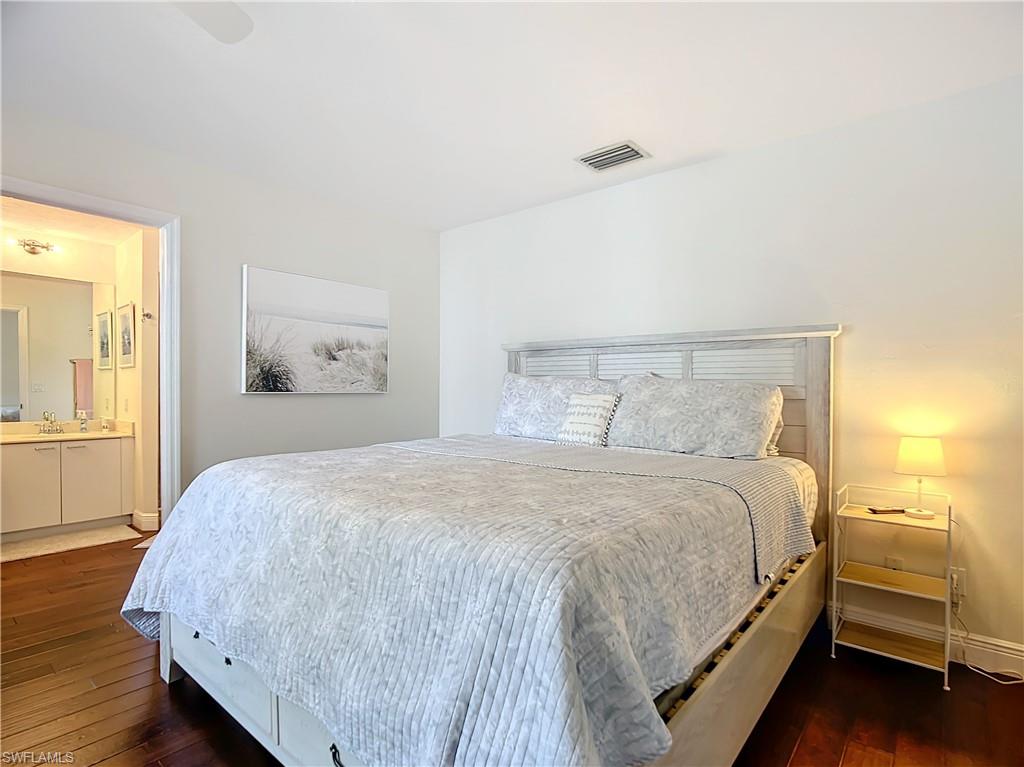 2860 Citrus Lake Drive, Unit R202 Naples, FL 34109 - Photo 33 of 50 a bedroom with a bed and wooden floor