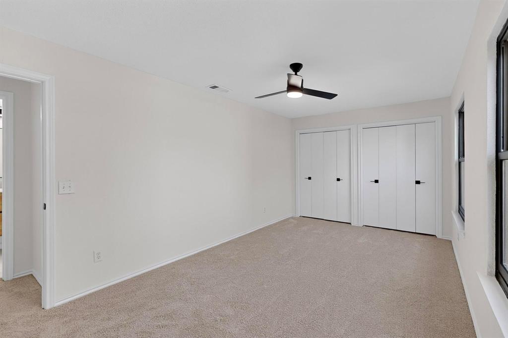 5009 Milam Street Dallas, TX 75206 - Photo 22 of 35 Unfurnished bedroom featuring multiple closets, light carpet, and ceiling fan