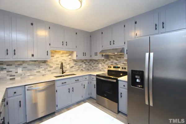 a kitchen with stainless steel appliances granite countertop a refrigerator sink and cabinets