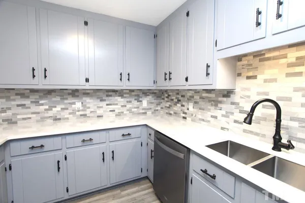 a kitchen with white cabinets and a sink