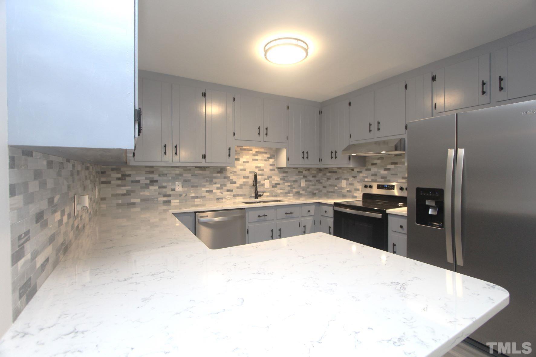 4161 Range Road Stem, NC 27581 - Photo 17 of 43 a kitchen with granite countertop a refrigerator sink and cabinets