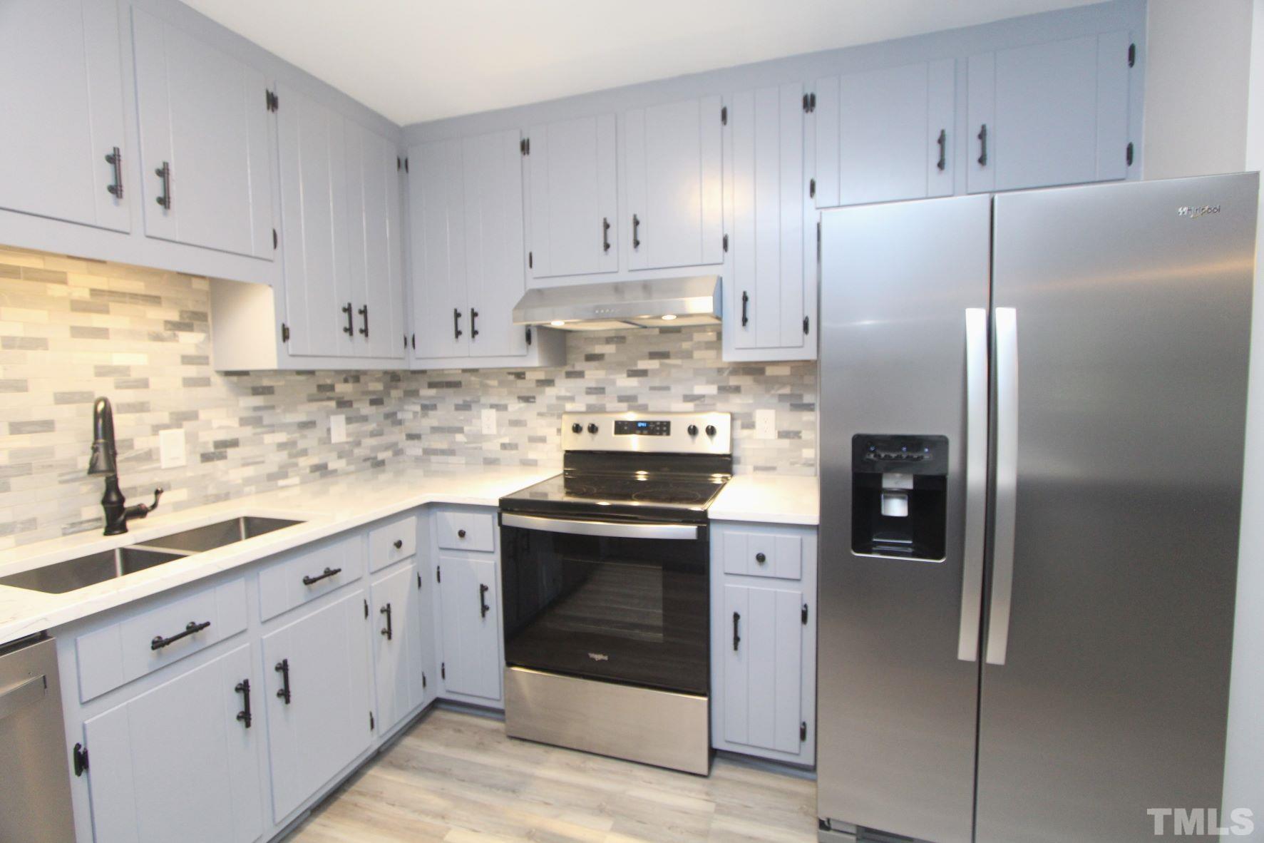 4161 Range Road Stem, NC 27581 - Photo 18 of 43 a kitchen with stainless steel appliances granite countertop a refrigerator stove and white cabinets