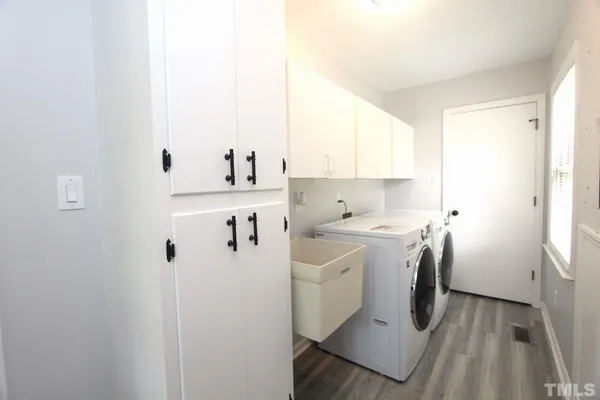 a utility room with cabinets washer and dryer