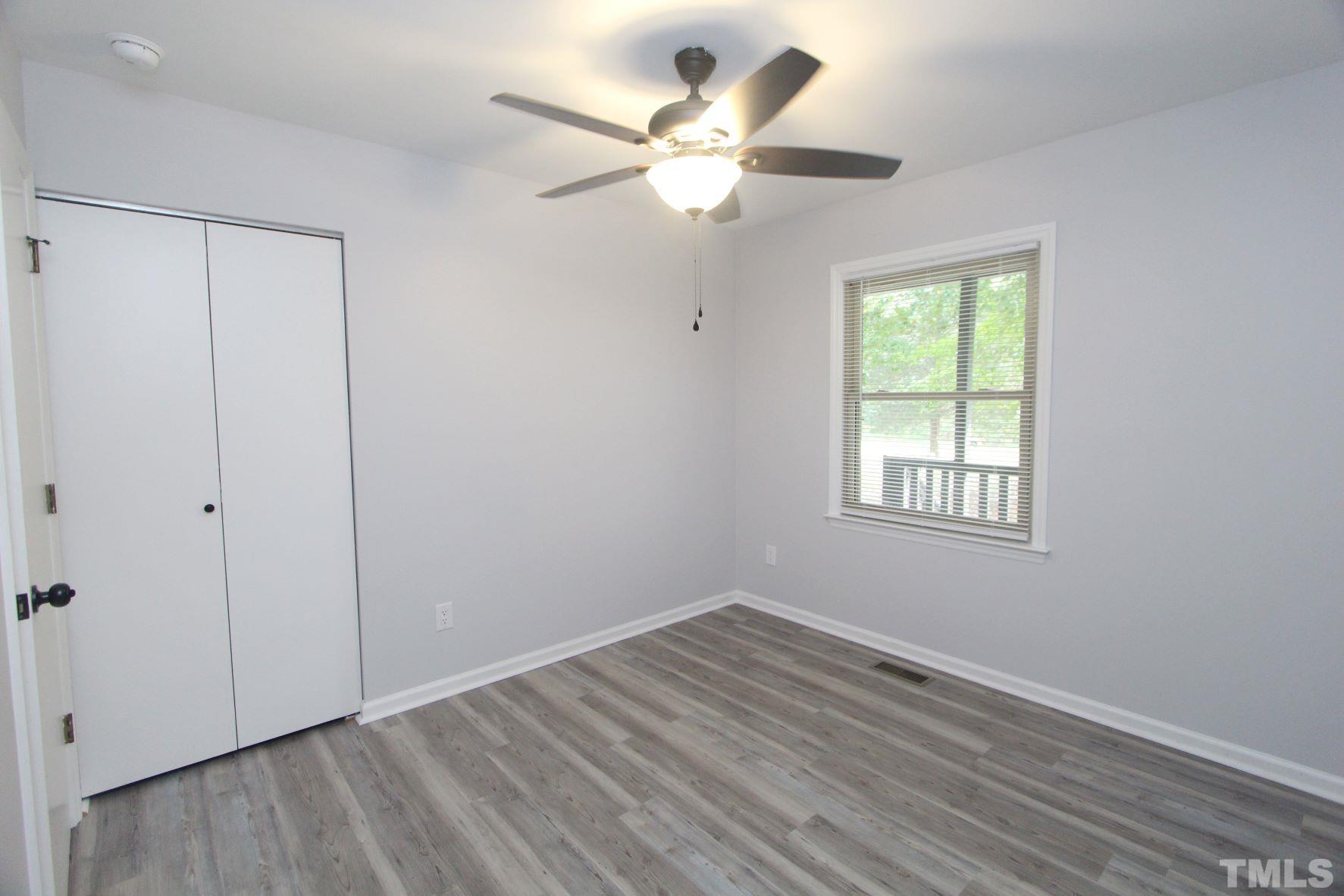 4161 Range Road Stem, NC 27581 - Photo 21 of 43 a view of an empty room with wooden floor and a window