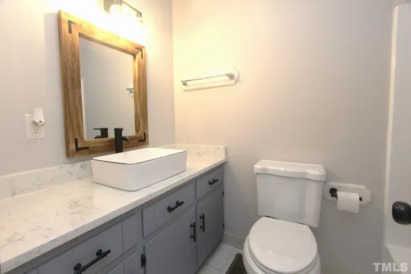 a bathroom with a granite countertop toilet sink and mirror
