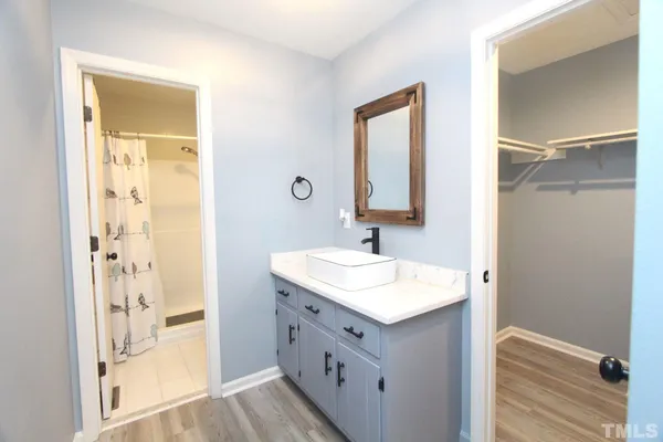 a bathroom with a sink a mirror and a shower