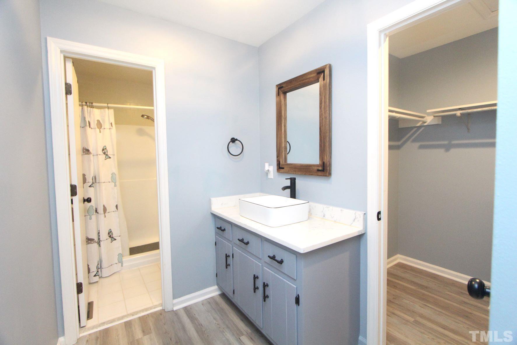 4161 Range Road Stem, NC 27581 - Photo 26 of 43 a bathroom with a sink a mirror and a shower