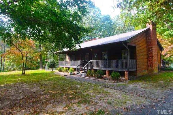 a view of a house with backyard and trees