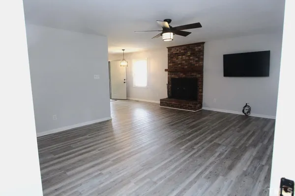 a view of a livingroom with wooden floor and a flat screen tv