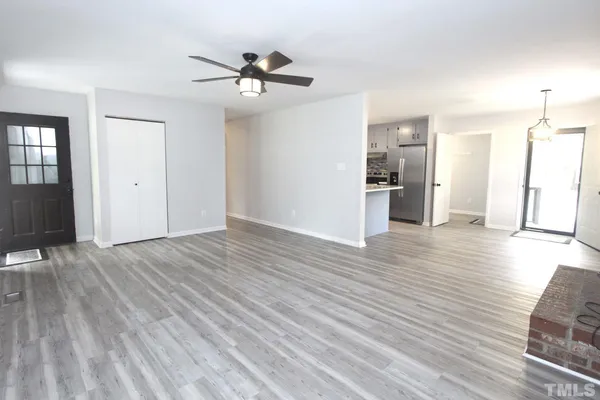a view of a room with wooden floor and ceiling fan