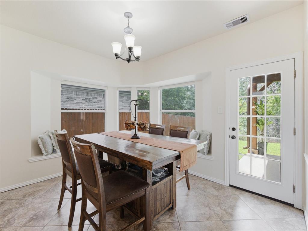 4008 Falcon Ridge Drive Haltom City, TX 76137 - Photo 13 of 40 Dining area featuring a bay window with a built-in bench, a full-lite exterior door, and tile flooring