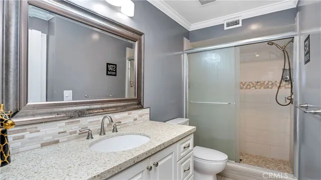 a bathroom with a granite countertop sink toilet and shower