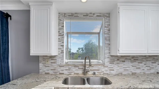 a kitchen with granite countertop a sink and a window