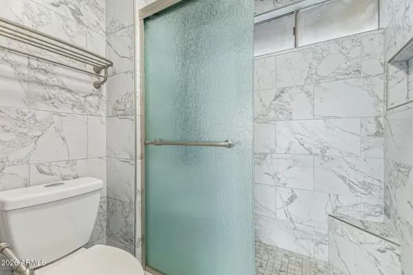 a white toilet sitting next to a shower curtain