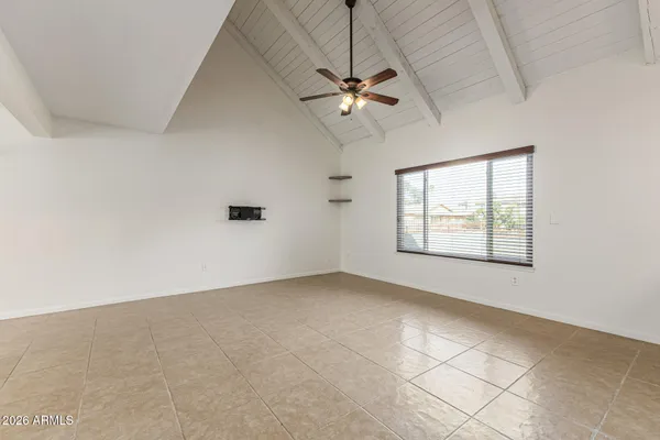 an empty room with windows and fan