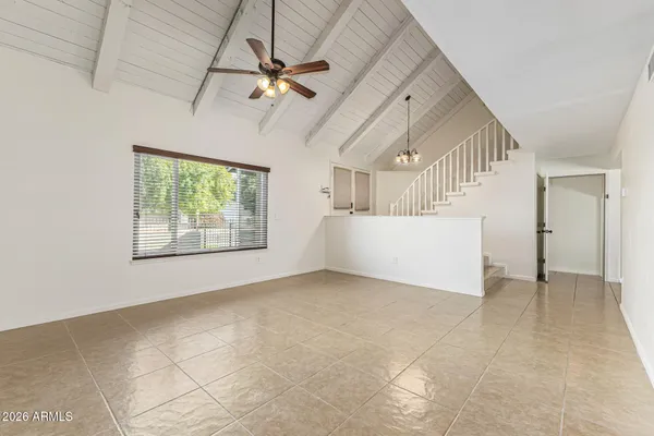 an empty room with windows and fan