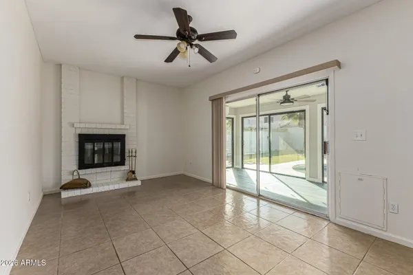 a view of an empty room with a fireplace and a window