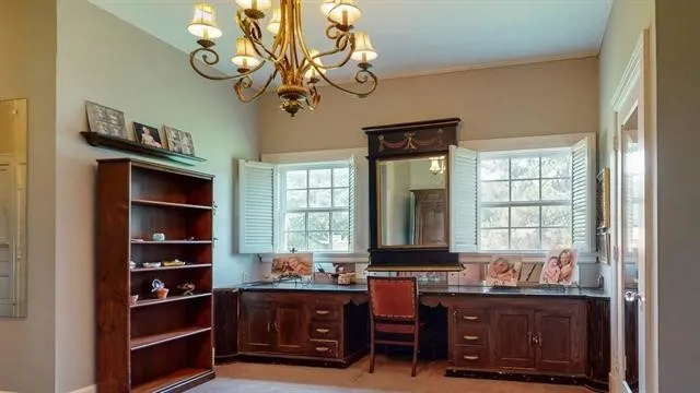 a view of a workspace with furniture and a window