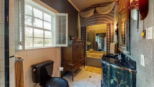 a spacious bedroom with a large bed a chandelier and closet