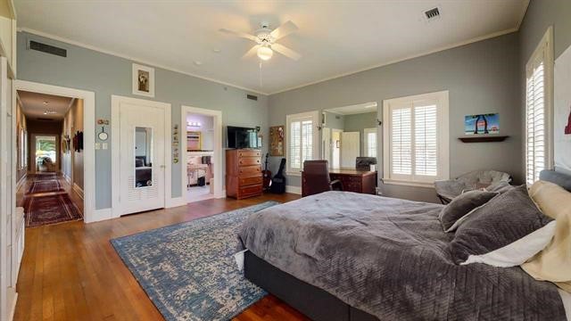 5975 Calder Avenue Beaumont, TX 77706 - Photo 18 of 35 a spacious bedroom with a large bed a chandelier and closet