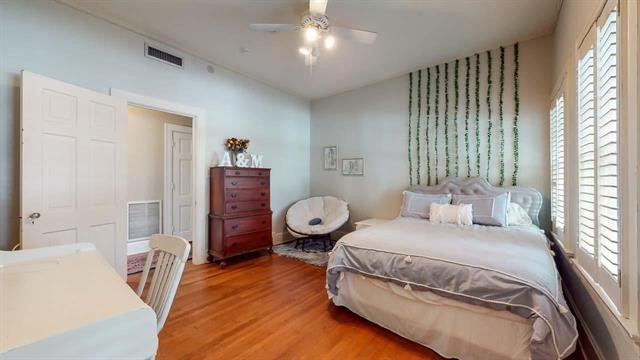 5975 Calder Avenue Beaumont, TX 77706 - Photo 21 of 35 a bedroom with a bed and wooden floor