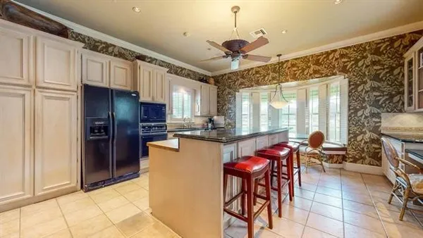 a kitchen with stainless steel appliances kitchen island granite countertop a refrigerator and microwave