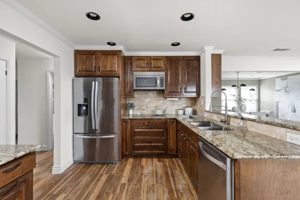 a kitchen with granite countertop a refrigerator and a sink