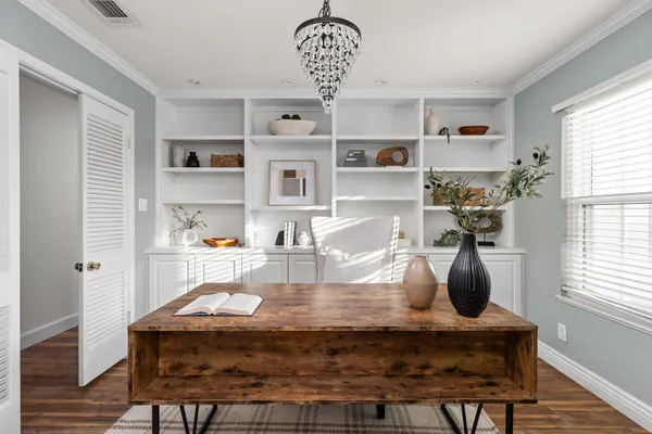 a room with a table chairs and chandelier
