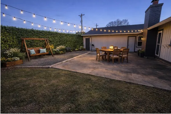 a view of a patio with table and chairs with wooden floor and fence