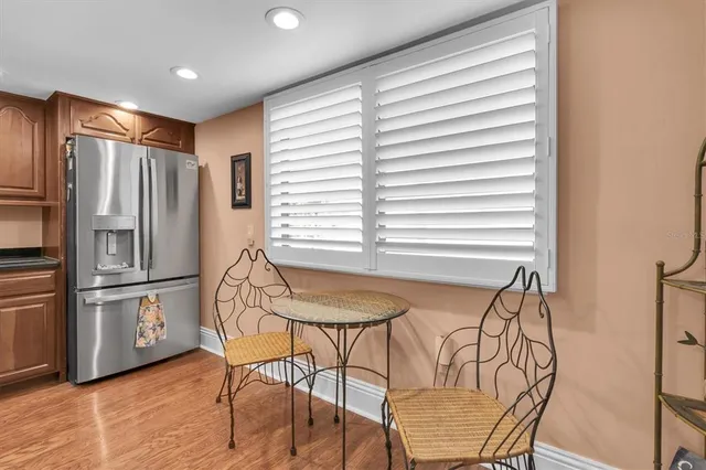 a kitchen with stainless steel appliances granite countertop a table chairs and a refrigerator
