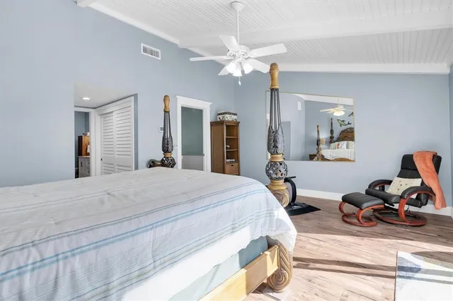 a bedroom with a bed and wooden floor