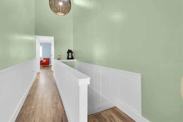 a view of a hallway with wooden floor and staircase