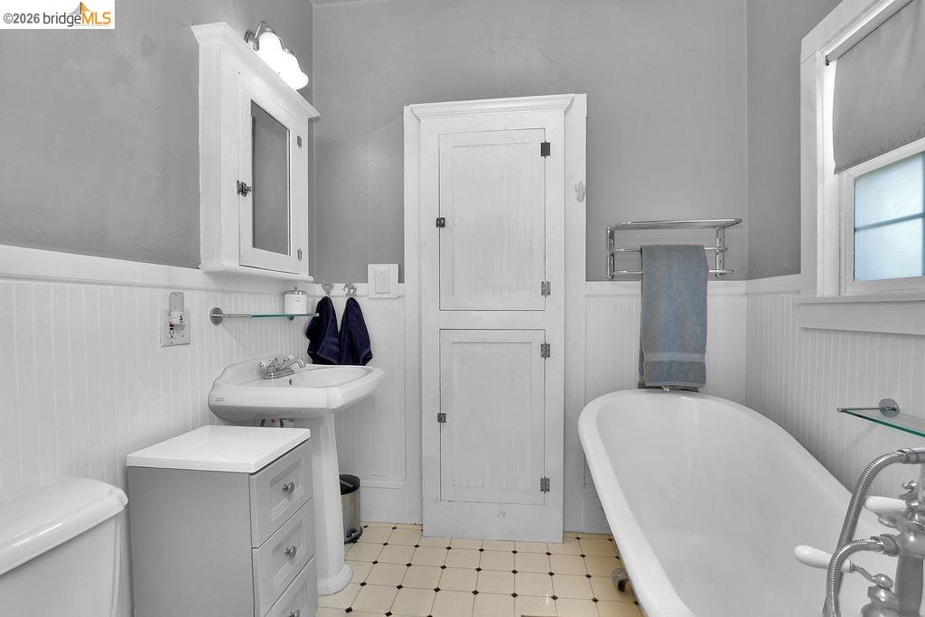 325 South 2nd Street Rio Vista, CA 94571 - Photo 13 of 33 Bathroom featuring a pedestal sink, a freestanding clawfoot tub, and white beadboard paneling