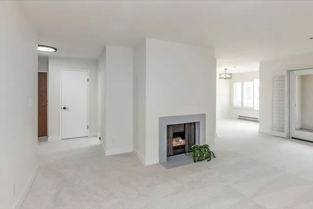 a view of an empty room with window and fire place