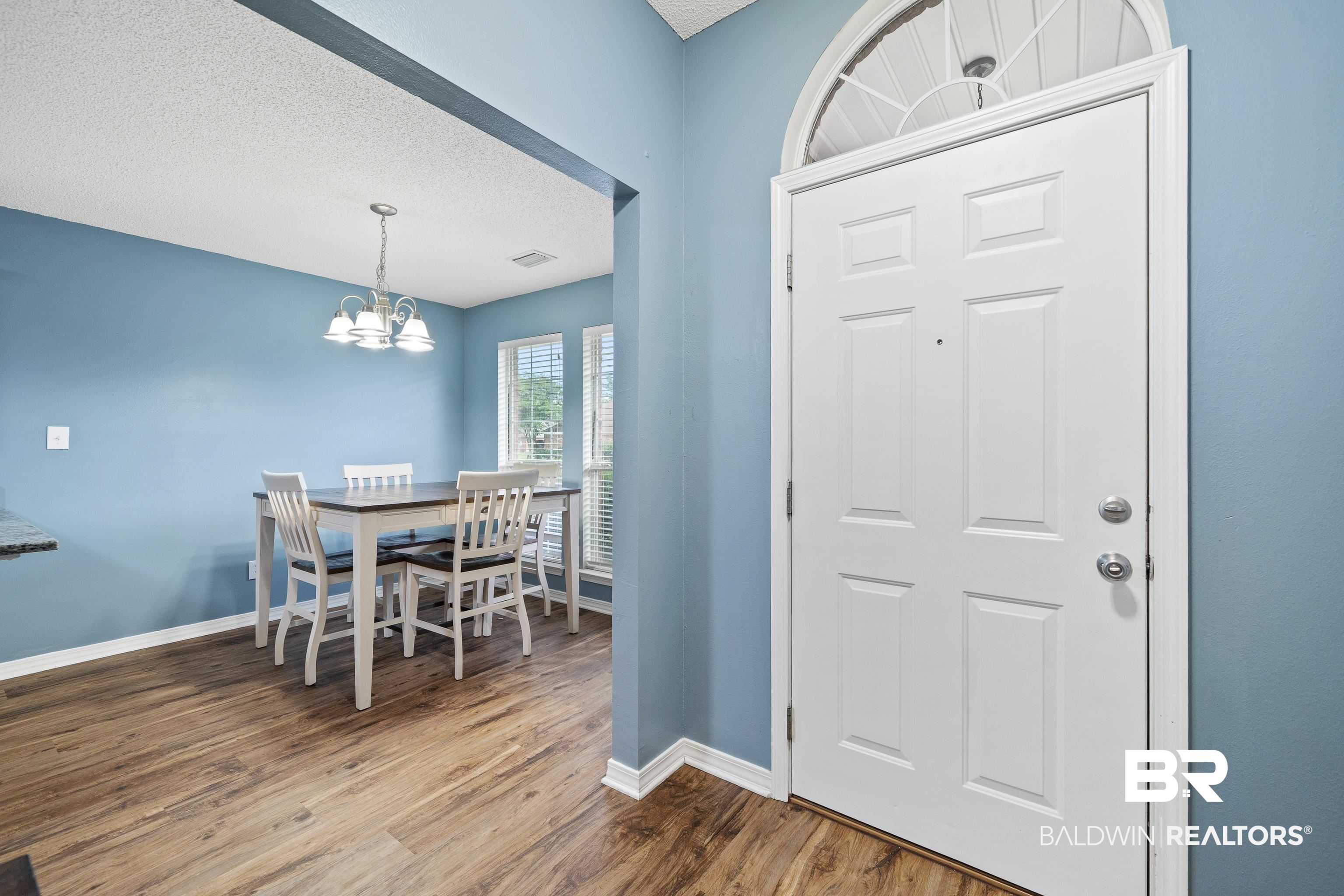 9552 Collier Loop Daphne, AL 36526 - Photo 5 of 28 Foyer with baseboards, wood finished floors, a chandelier, and a textured ceiling