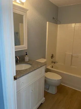 a bathroom with a granite countertop sink toilet and shower