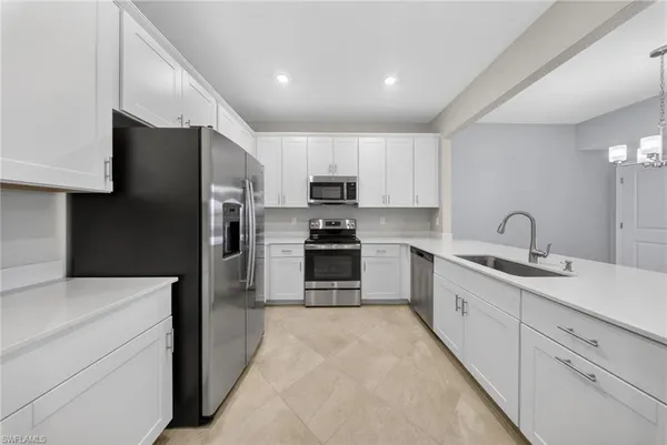 a kitchen with stainless steel appliances granite countertop a refrigerator sink and cabinets