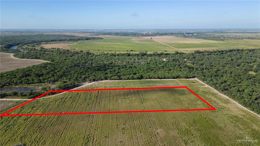 0 Eustacio Flores Road Sullivan City, TX 78595 - Photo 3 of 5 Expansive rear aerial view of the lot, showcasing lush surroundings and proximity to farmland and natural water sources.