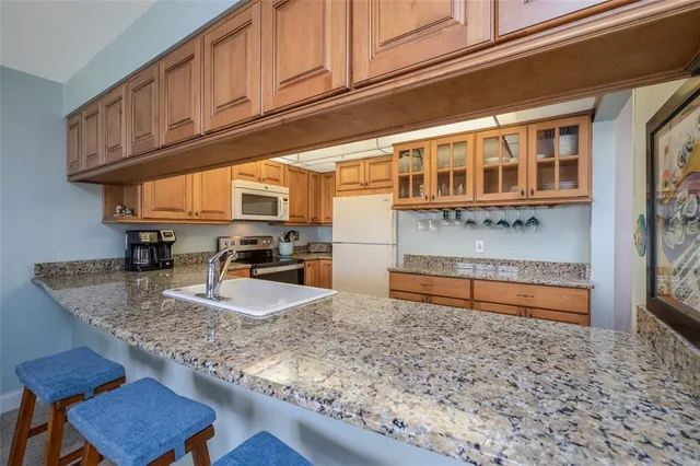 a kitchen with stainless steel appliances granite countertop a sink stove and granite counter top