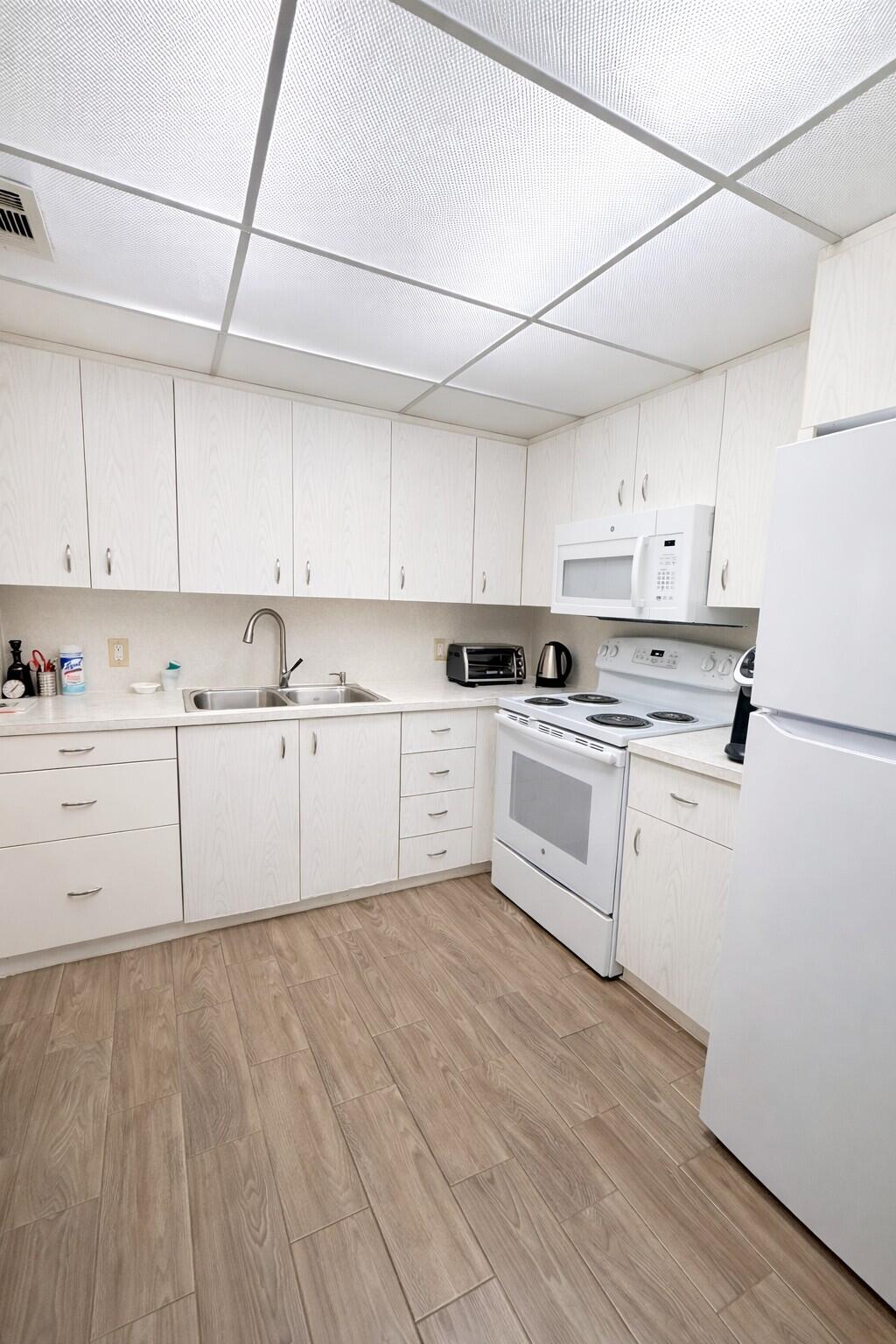 3030 Wolverton East Boca Raton, FL 33434 - Photo 5 of 13 a kitchen with cabinets a sink and white appliances