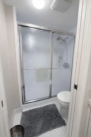 a bathroom with a glass door shower and toilet