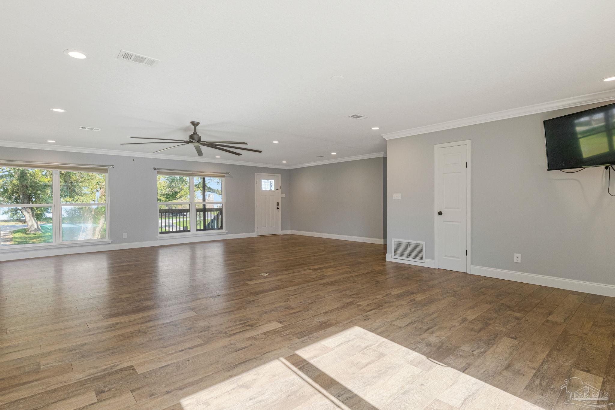 302 Garcon Point Road Milton, FL 32583 - Photo 15 of 51 an empty room with wooden floor and windows