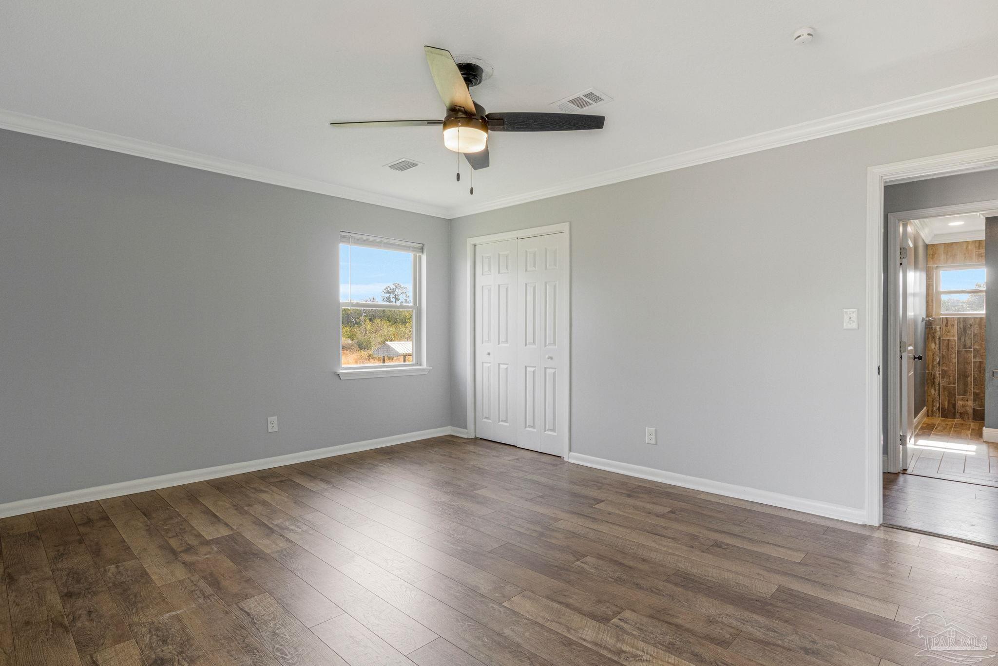 302 Garcon Point Road Milton, FL 32583 - Photo 17 of 51 a view of an empty room with wooden floor and a window