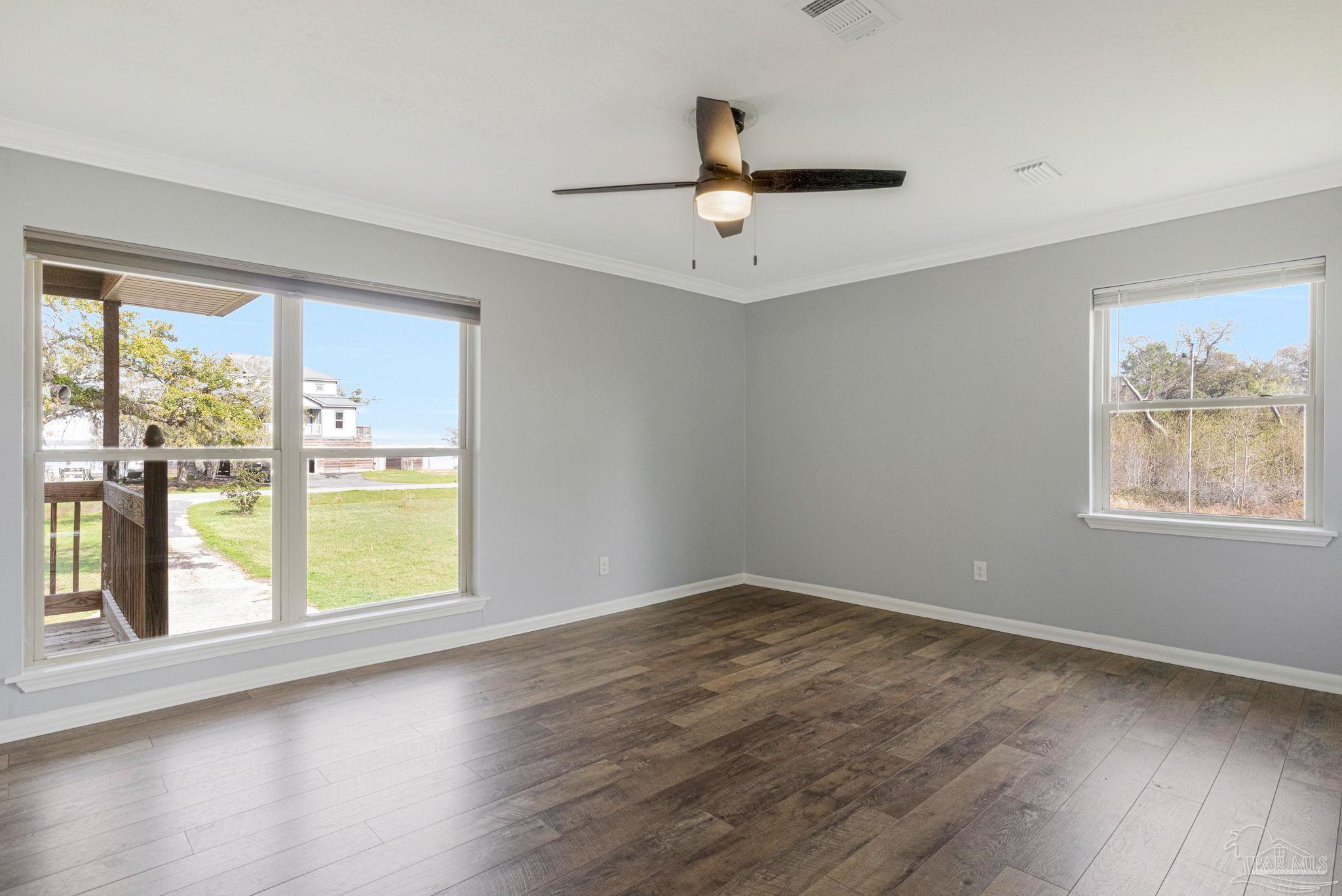302 Garcon Point Road Milton, FL 32583 - Photo 20 of 51 a view of an empty room with wooden floor and a window