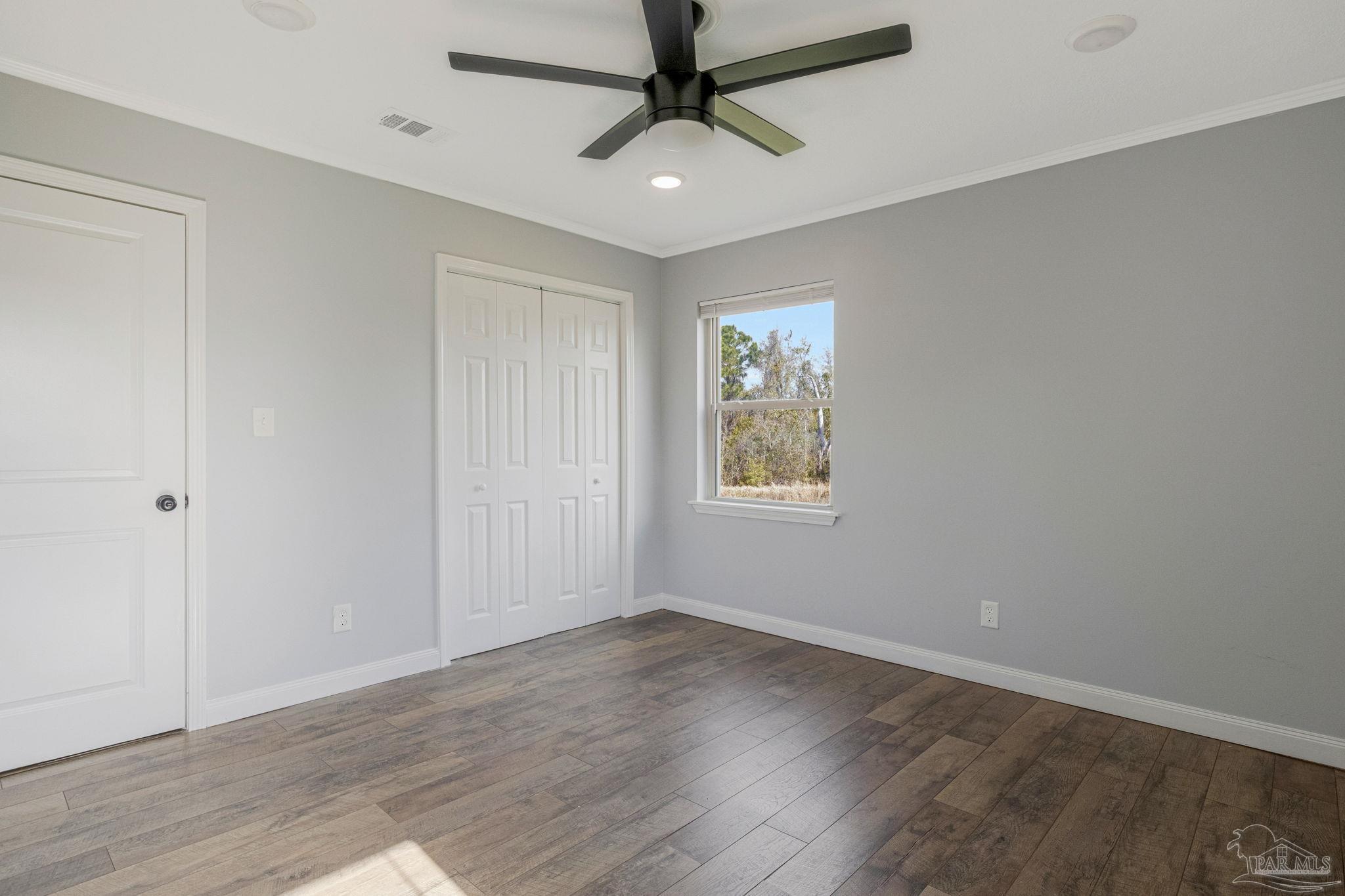 302 Garcon Point Road Milton, FL 32583 - Photo 22 of 51 wooden floor in an empty room with a window